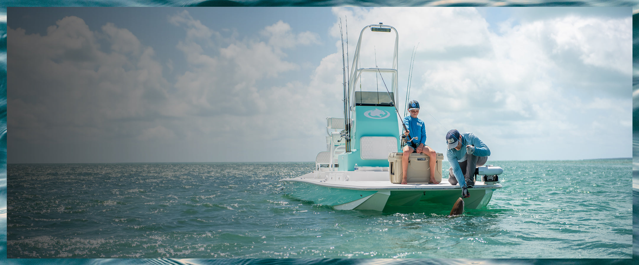 Father and son next to a hard cooler while fishing on a boat