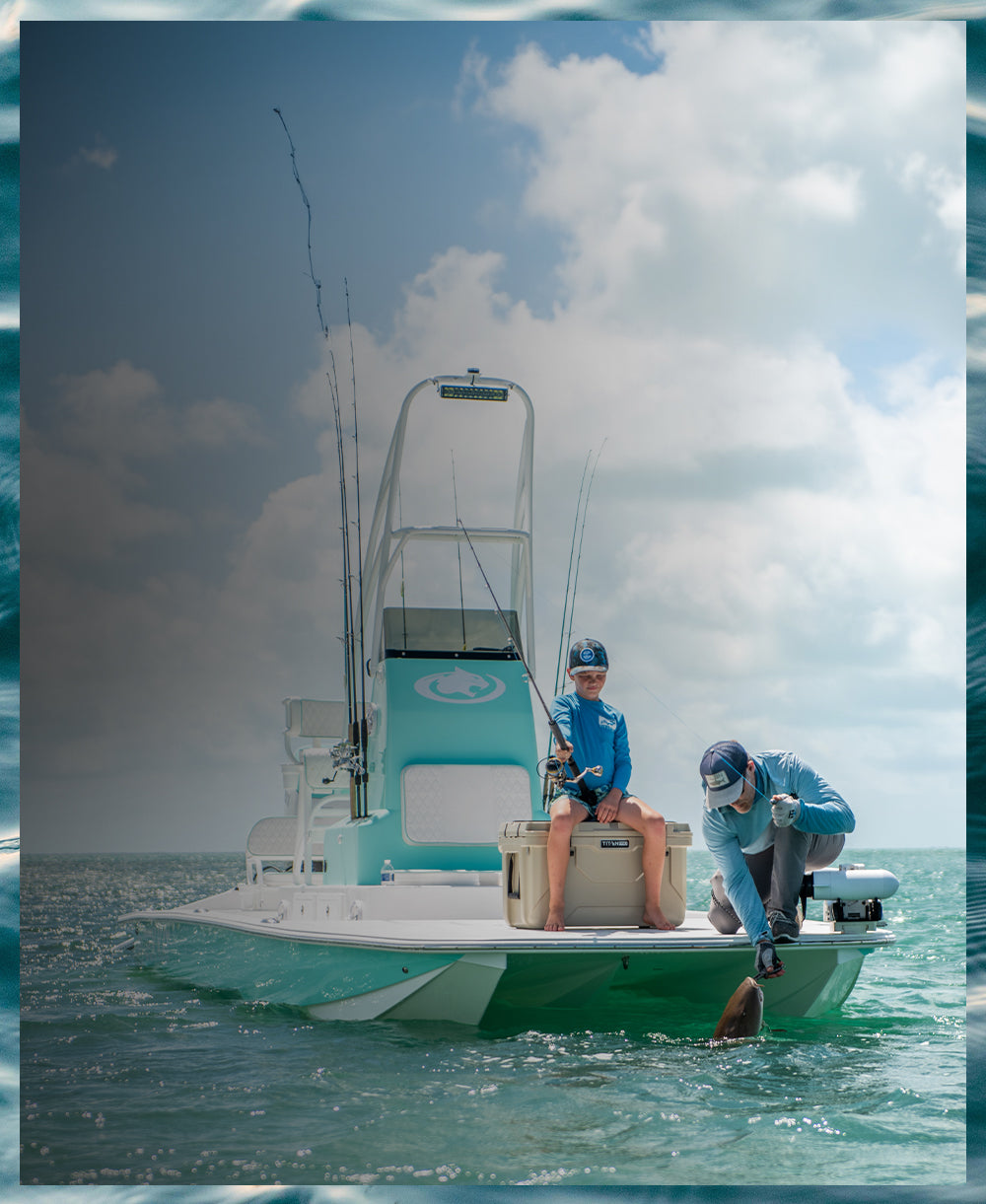 Father and son next to a hard cooler while fishing on a boat